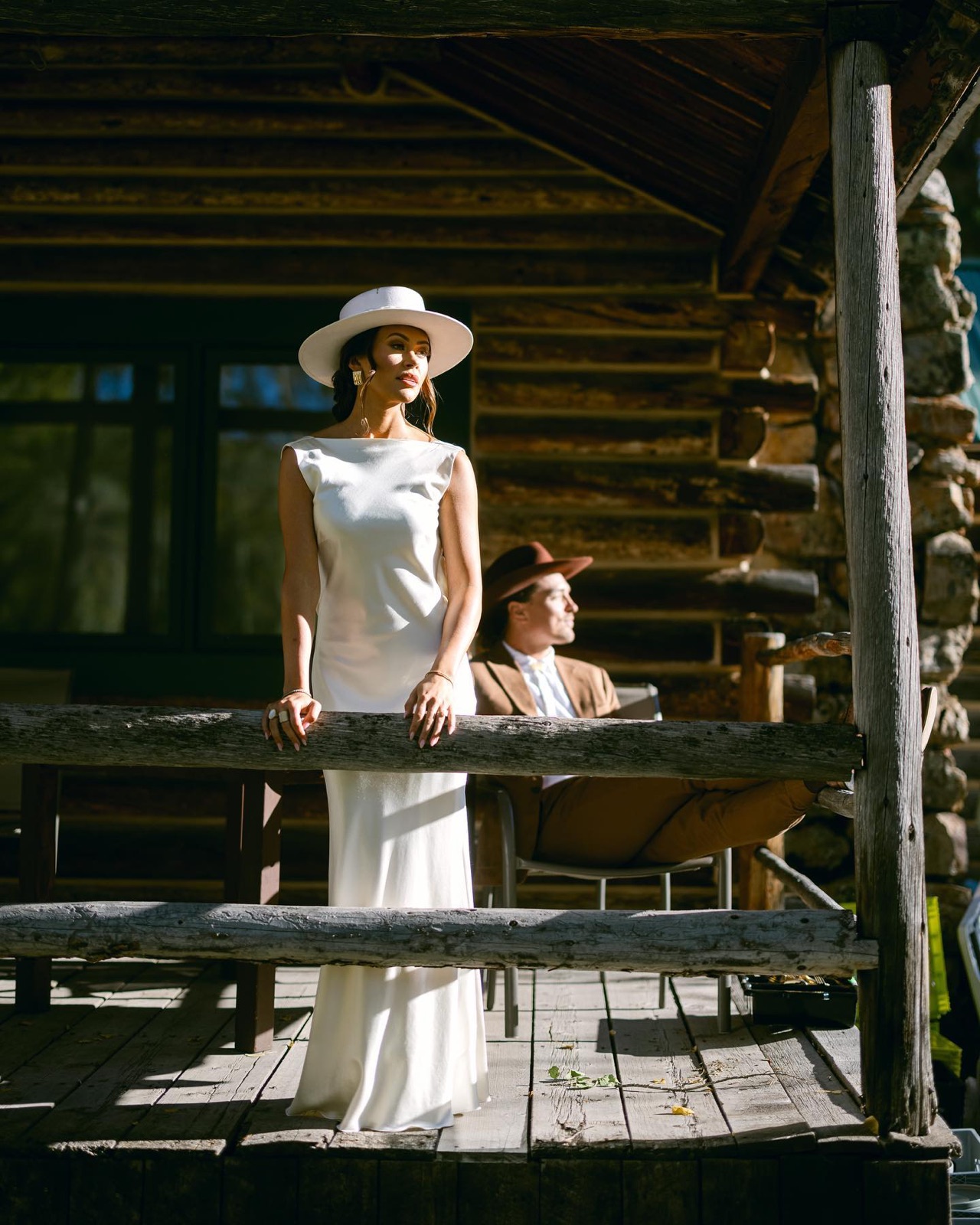 Bride and groom on a sunlit cabin porch at Beyul